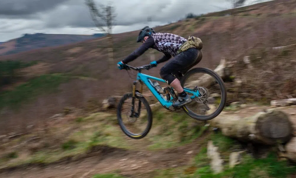 MTB rider on a yeti dropping off a log