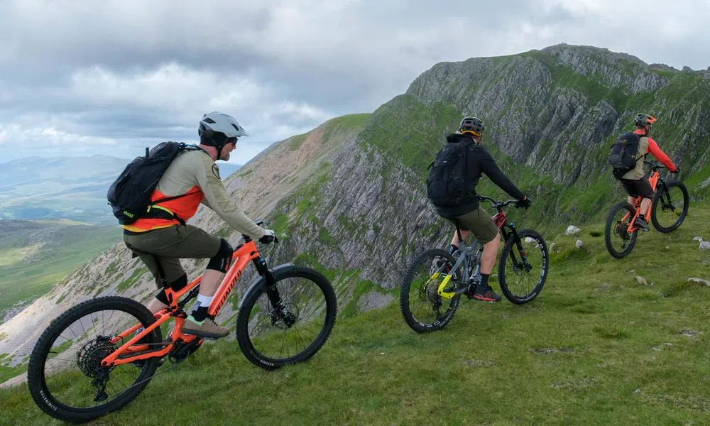 Mountain bikers on e-bikes cycling up towards Cadair Idris