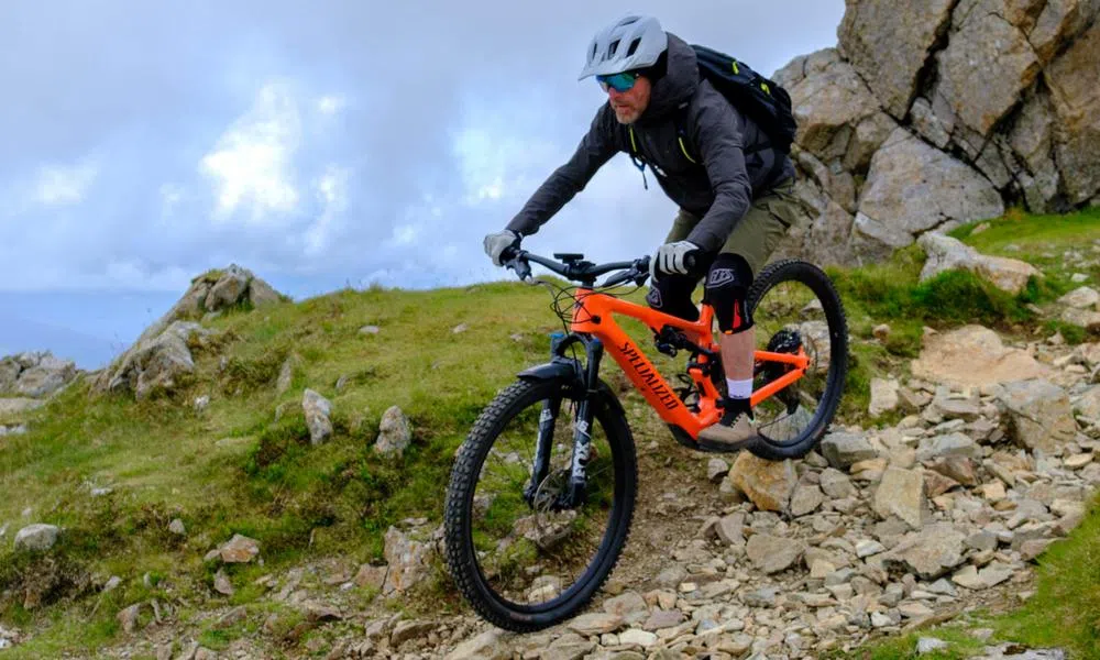 mountain biker on an ebike wearing knee pads