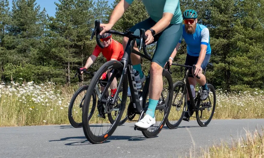 road cyclists riding close up showing shoes and wheels