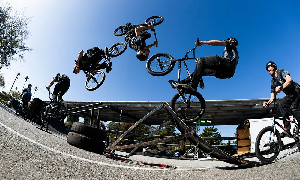 A BMX rider does a backflip onto a grind rail