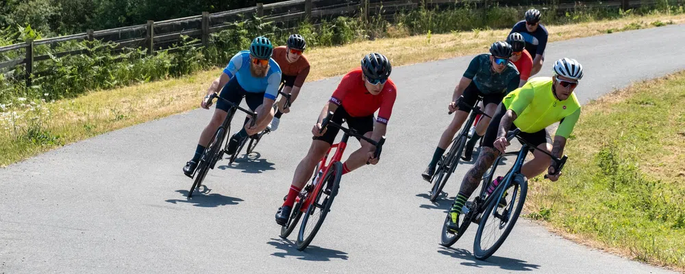 Peleton of road riders cornering at speed