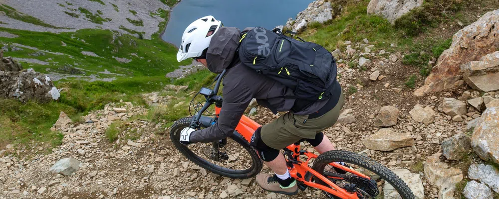 mountain biker riding with evoc backpack