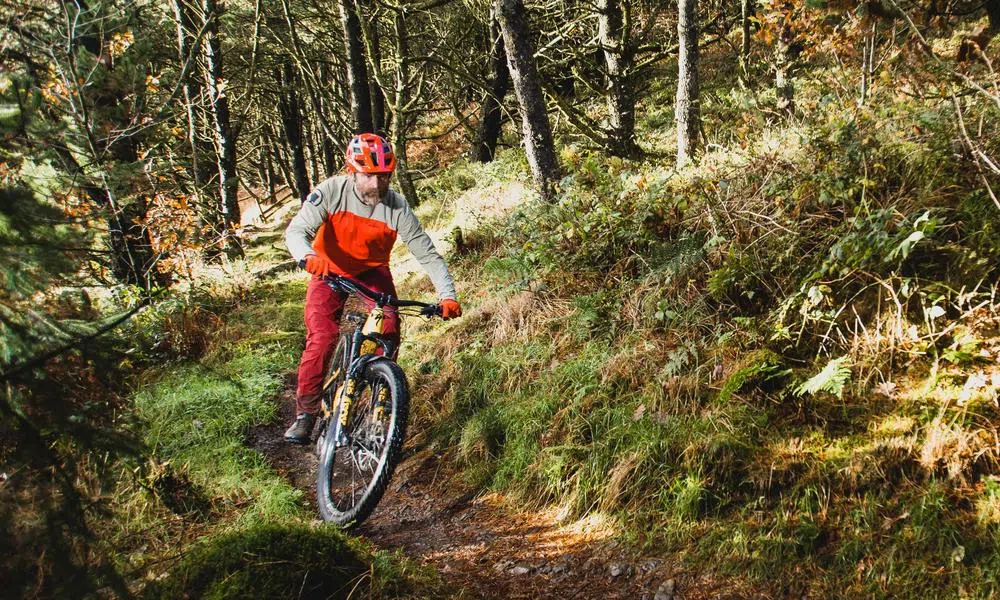 mountain electric bike on trail, rider in red endura kit