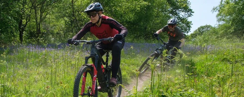 Woman and man riding electric mountain bikes on a spring day