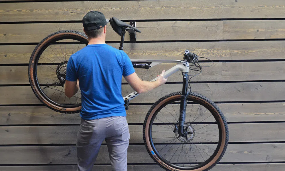 man hanging a bike on a wall mounted bike stand