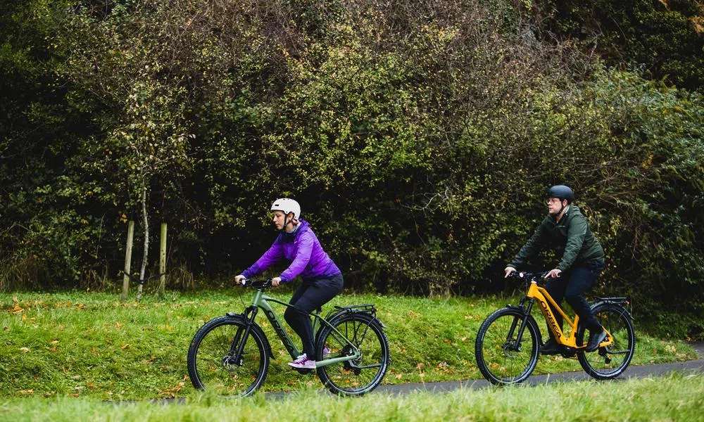 Two orbea bikes riding on a path