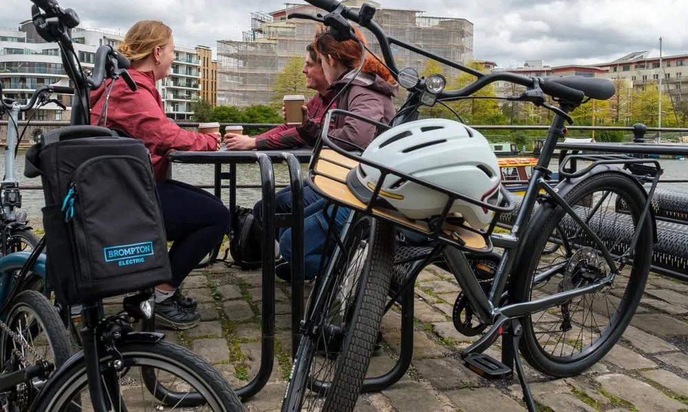 cyclists chatting in background with Brompton electric an boardman hybrid bikes in foreground