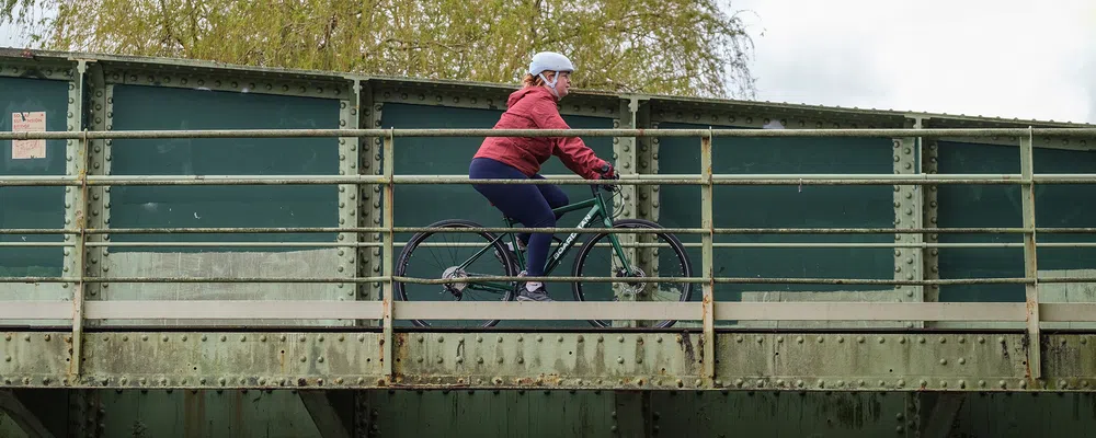 a hybrid sports bike is ridden across a bridge