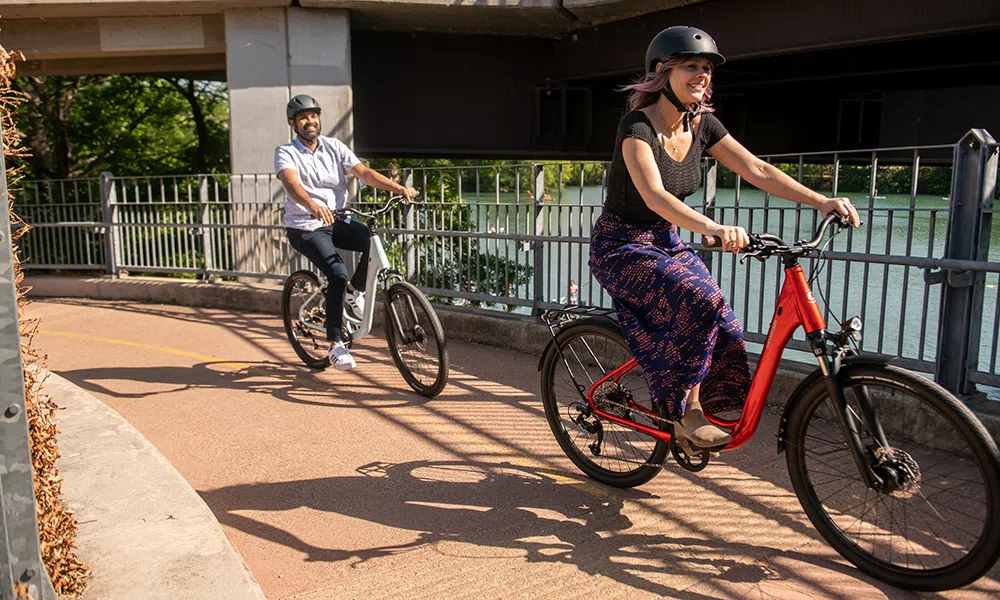 Hybrid bikes are ridden across a bridge near a river