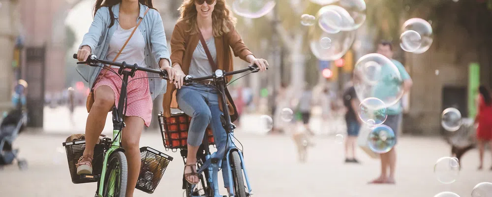 two women riding bikes with rear baskets