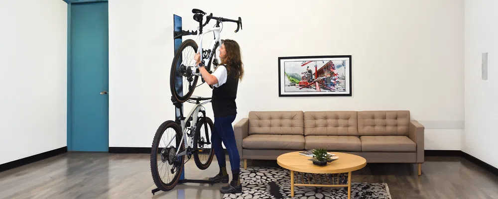 woman hanging bike on floor mounted bike storage 