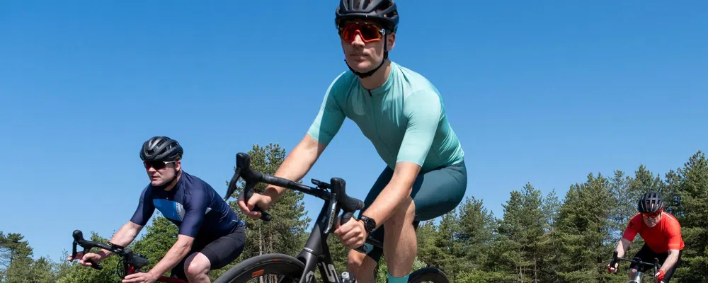 road cyclists riding with short sleeve jerseys on a summer day