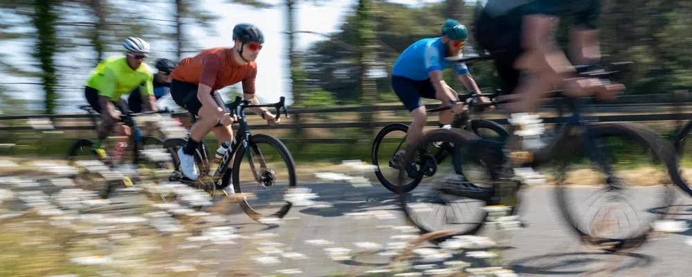 a group of road riders race past