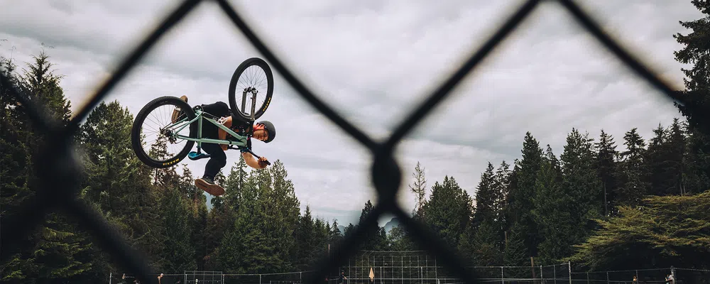 a rider on a jump bikes does a one footed invert 