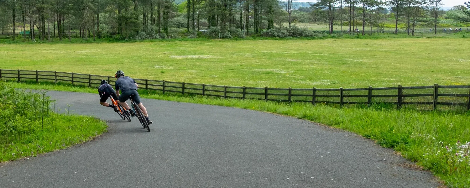 two cyclists on downhill corner on road and gravel bikes