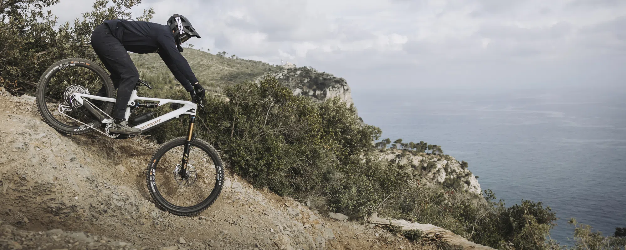 a Merida e-mtb is ridden downhill near the sea