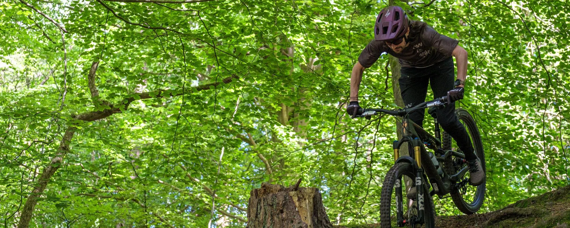 a mountain bike is ridden downhill the rider is wearing northwave clothing