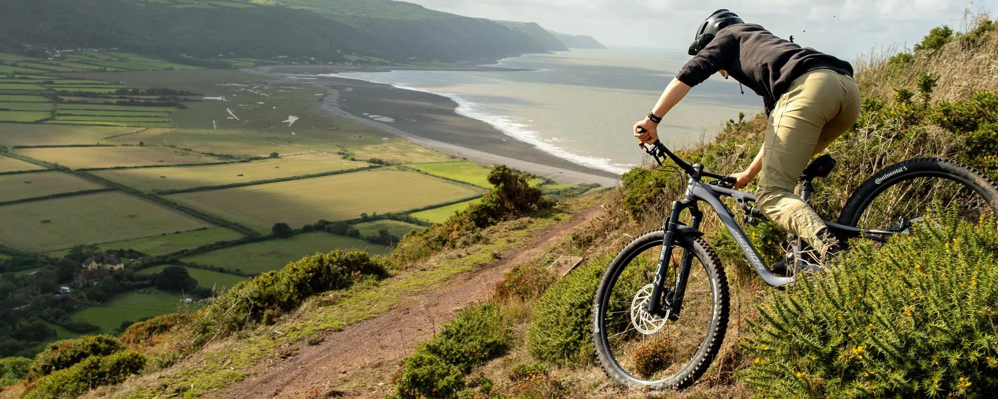 riding a merida mountain bike downhill next the the seaside