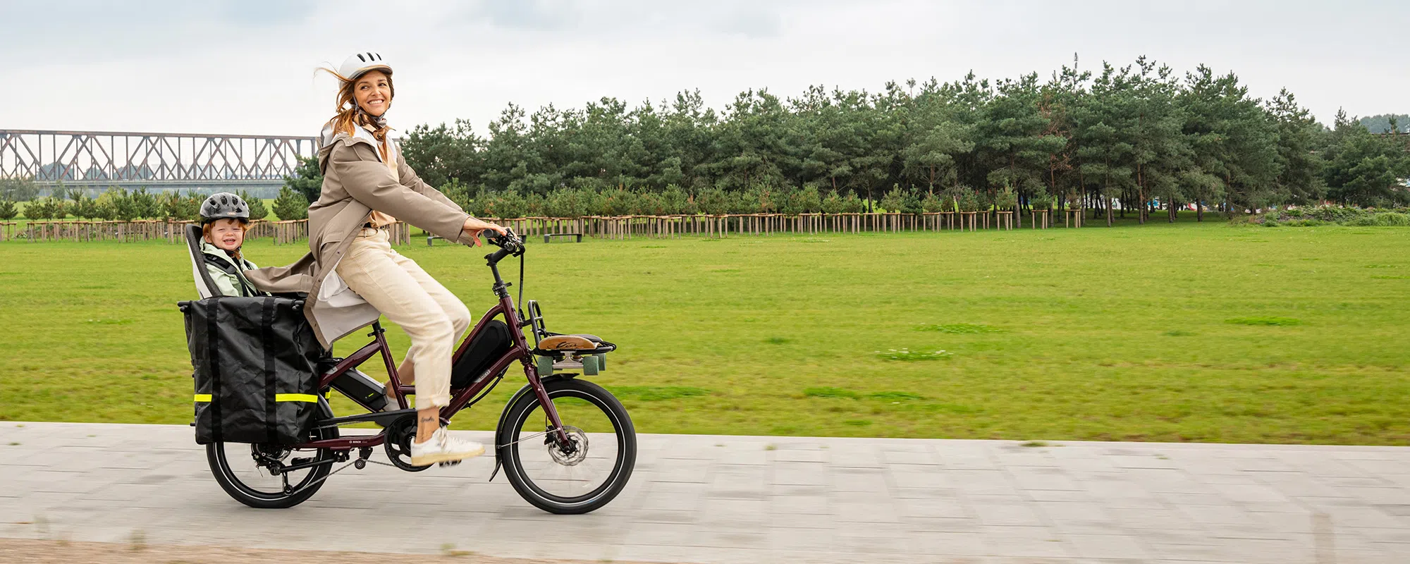 Woman riding a Tern e-bike with child on the back 