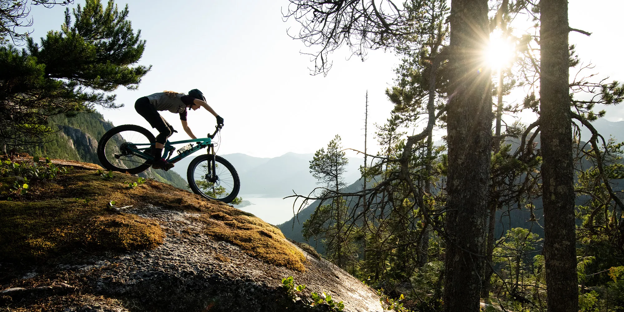 Mountain bike rider on steep technical terrain overlooking the ocean in the sunshine with Bontrager wheels