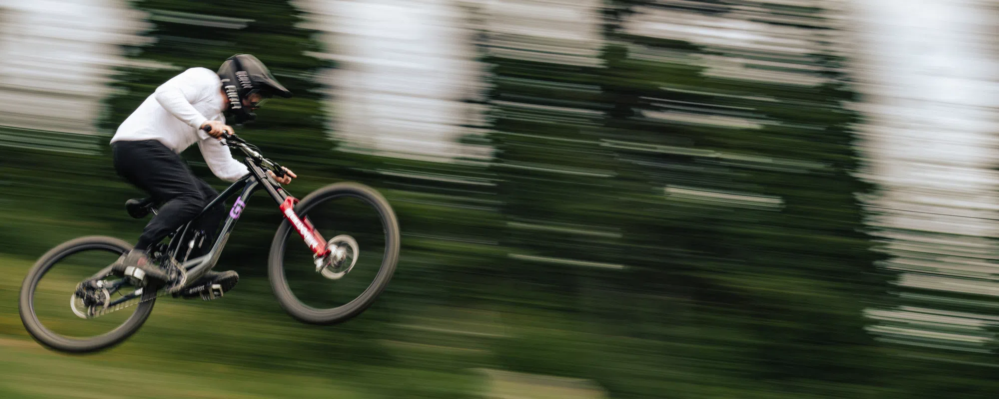 A GT downhill bike flies through the air at high speed