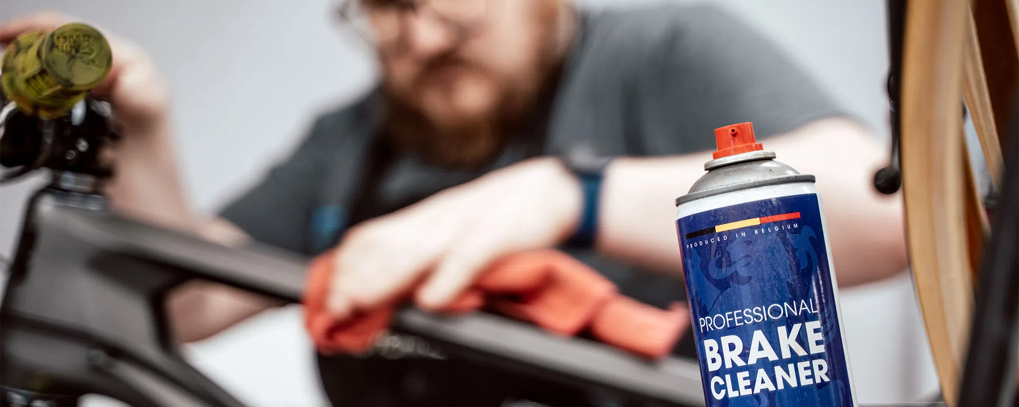 ike mechanic working on bike with MOrgan Blue disc brake cleaner in teh forground