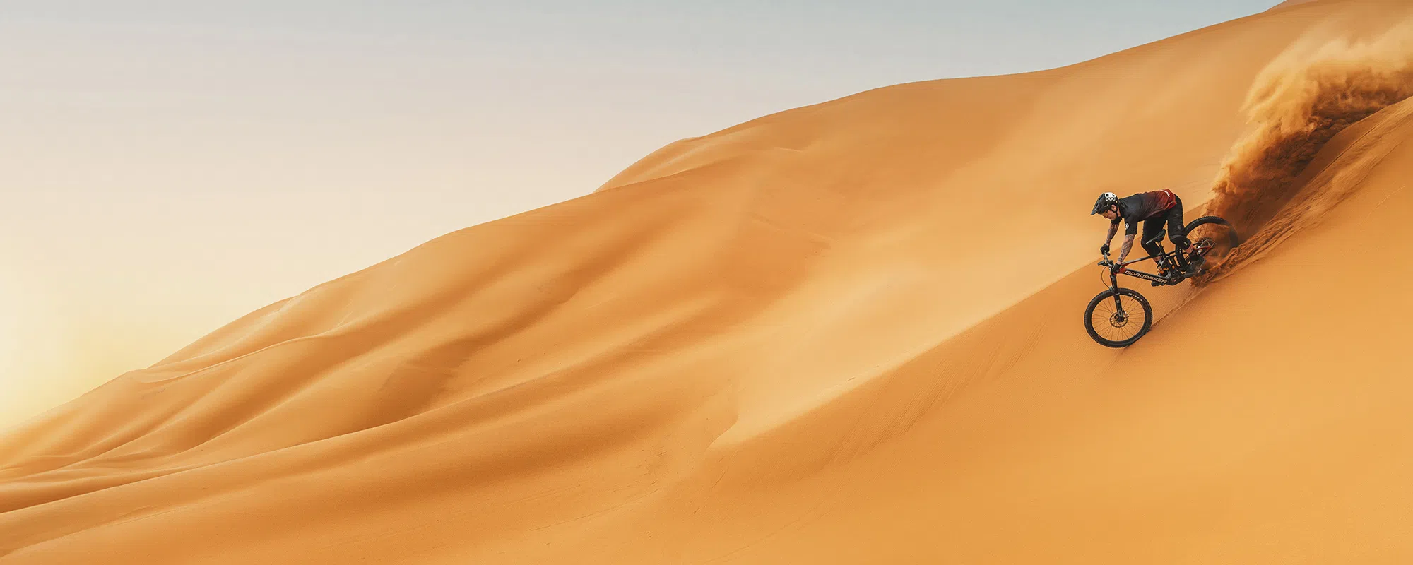 A Mondraker e-bike is ridden down a sand dune