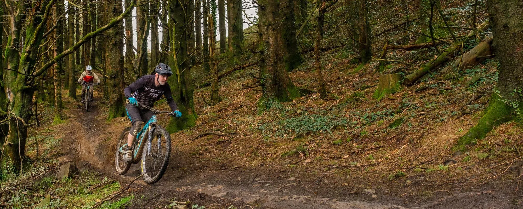 two yeti mountain bikes on trail in the woods