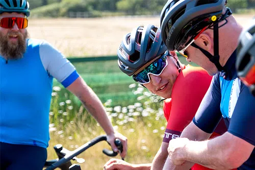 road cyclists in helmets and glasses chatting 