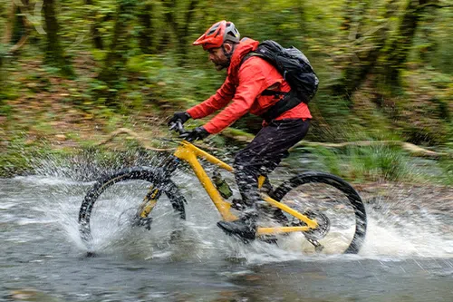 Riding an electric mountain bike through a river splash