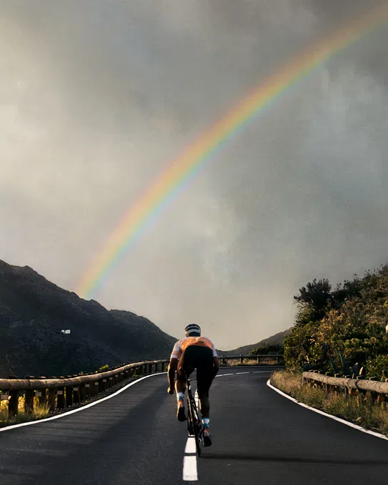 Riding a Cannondale road bike under a rainbow