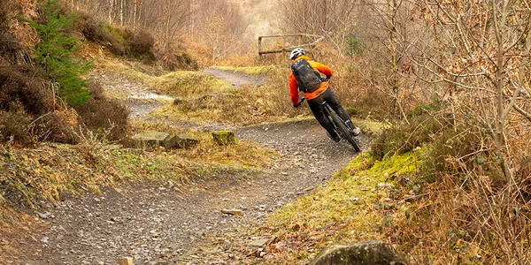 riding a Cube e-bike on blue bermed trail