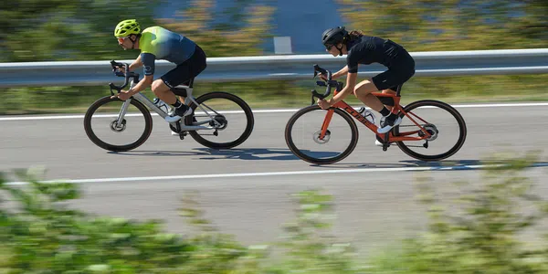 two road cyclists riding quickly