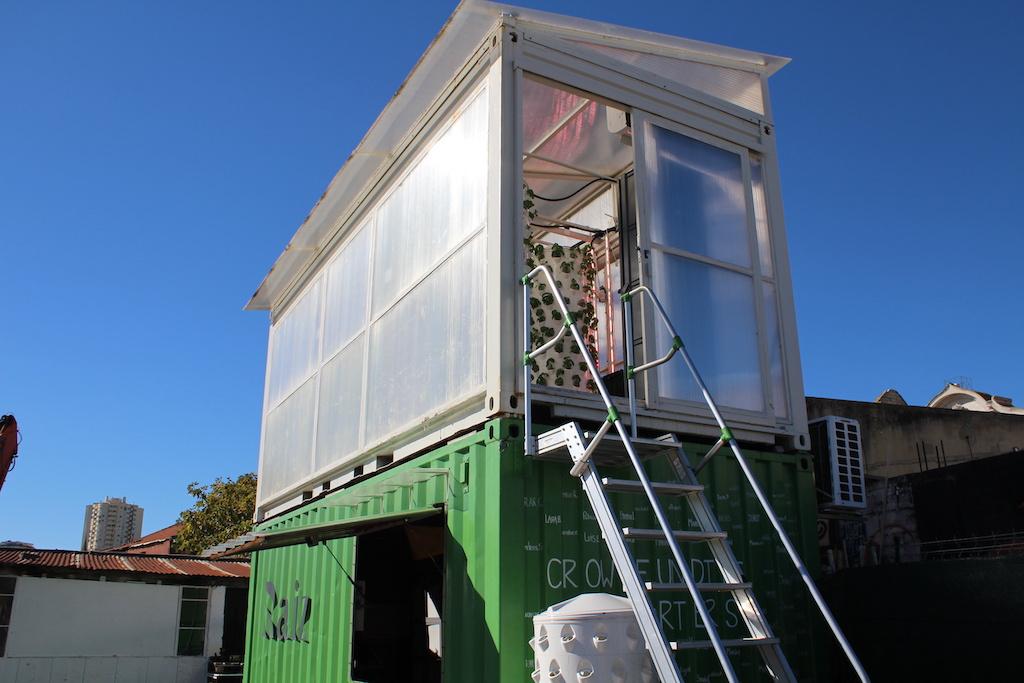 Two stacked-up containers forming city farms with hydroponic towers in the top container for the vertical farming blog