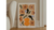 modern orange wall art in white frame placed on the wooden floor