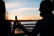  a couple facing a beach cheersing during a sunset