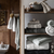 wooden bathroom storage filled with white towels 