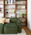 green sofa in front of decorative bookcase