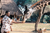 a man feeding a giraffe by a hut