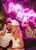 smiling newlyweds in front of neon signage decor