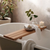 wooden bath ledge with plant and candle on top of it 