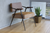 brown cushioned arm chair in showroom with potted plant and mirror 