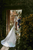 newlyweds walking holding hands through a floral doorway