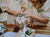 Wedding presents wrapped in brown paper with white ribbon and flower garnishes being unwrapped by two flower girls in ivory dresses