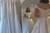 Influencer Petite Ellie is trying on wedding dresses, while looking into mirror