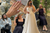 A college of Petite Ellie trying on a petite wedding dress, showing her engagement ring and wearing a selection of black dresses