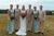 Bride and groom pose with their groomsmen and bridesmaids in matching looks