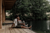 bride and groom sitting at the edge of a loge by the river