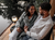 A couple sat together smiling and holding hands on a wooden deck overlooking a lake